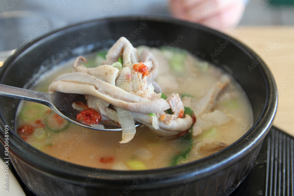 Korean pork rice soup (Dwaeji-gukbap) with the focus on pig stomach in a steaming stone bowl at Korean restaurant, Busan, South Korea Korean pork rice soup (Dwaeji-gukbap) with the focus on pig stomach in a steaming stone bowl at Korean restaurant, Busan, South Korea