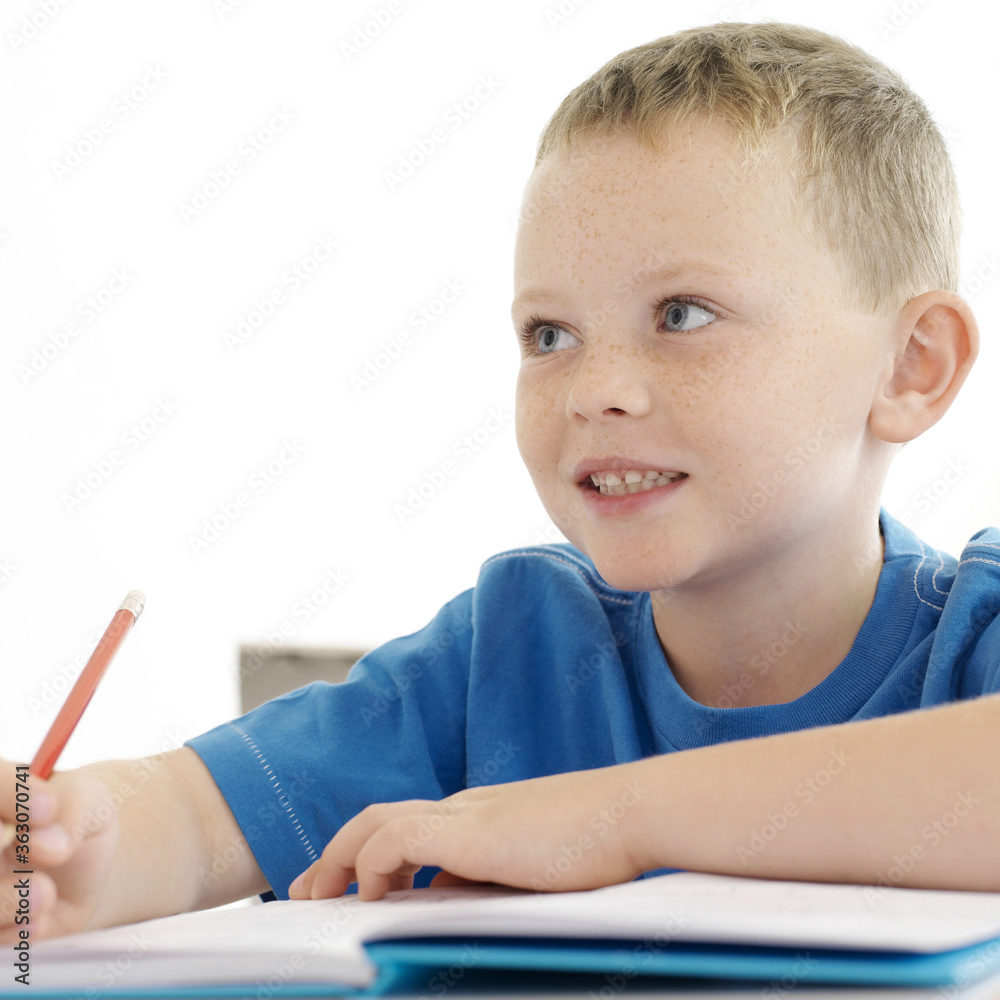 Boy looking away while holding a pencil Boy looking away while holding a pencil