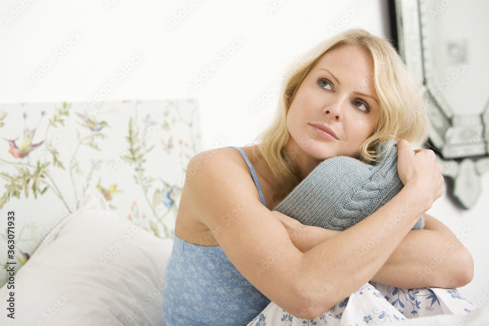 Woman looking up while hugging hot water bottle Woman looking up while hugging hot water bottle