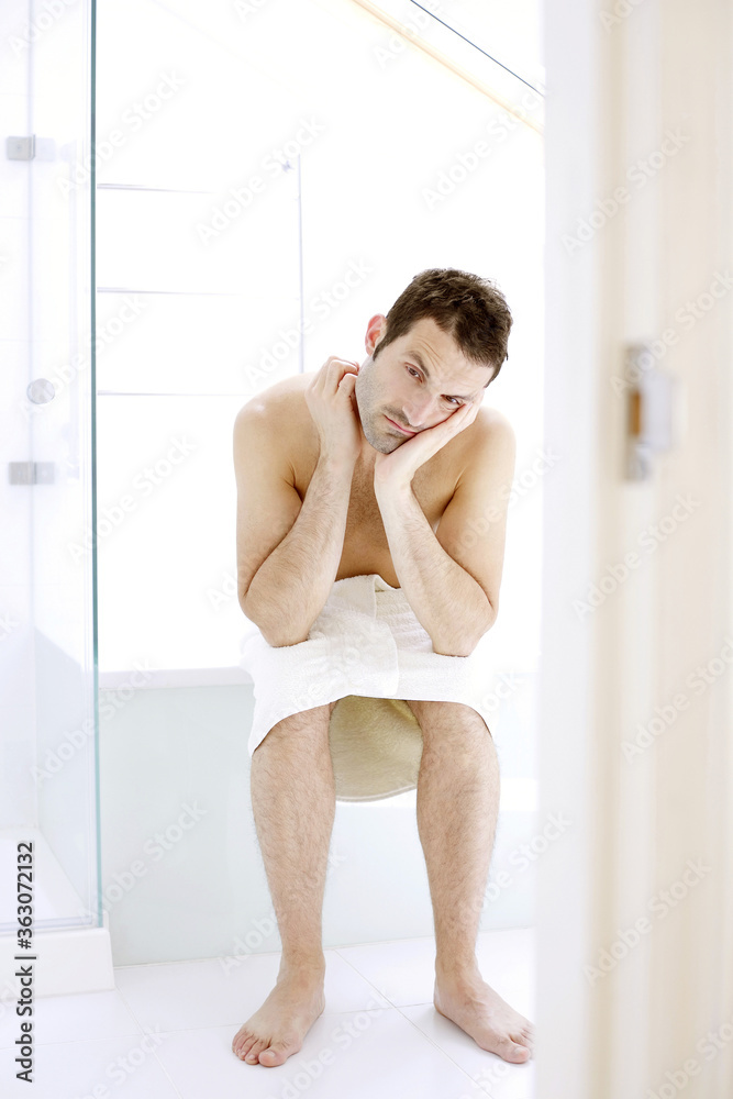 Man with towel sitting in the bathroom Man with towel sitting in the bathroom
