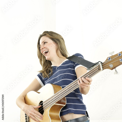 Woman laughing while playing guitar