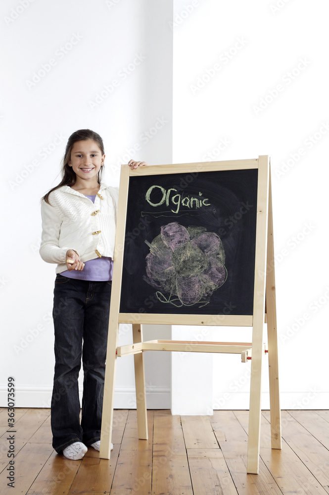 Girl smiling and holding onto blackboard Girl smiling and holding onto blackboard