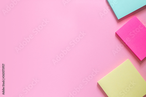 Three multi-colored stickers on a delicate pink background. Place for text.