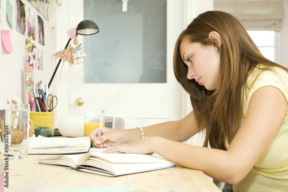 Girl doing assignment in her room Girl doing assignment in her room