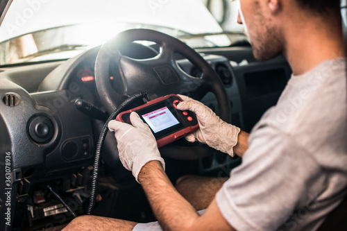Auto mechanic using car scanner diagnostic tool
