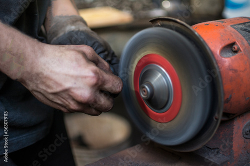 Worker using a bench grinder