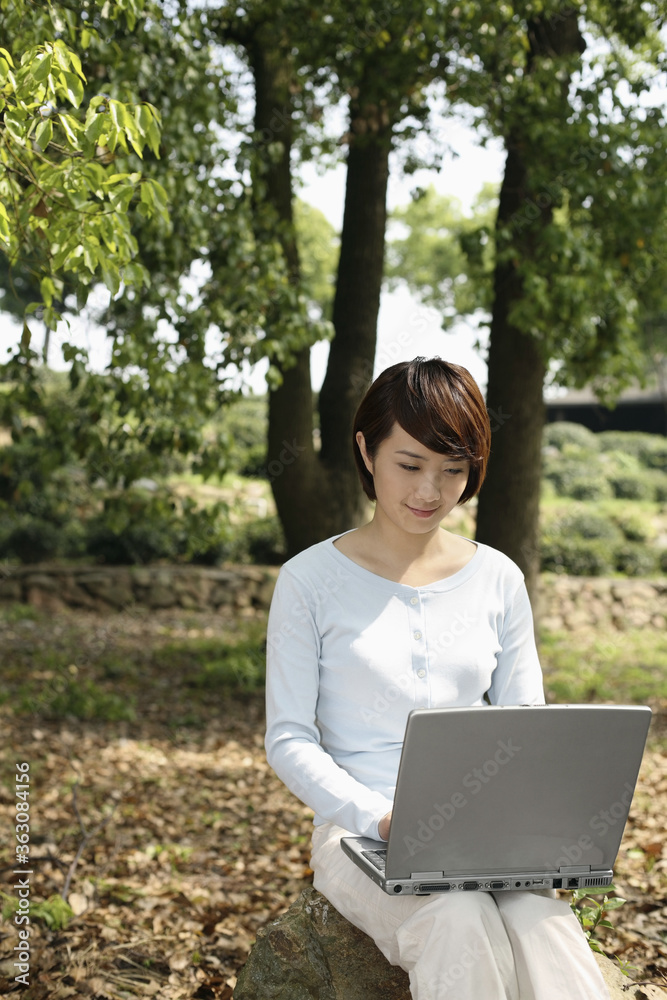 Woman using laptop in the park Woman using laptop in the park