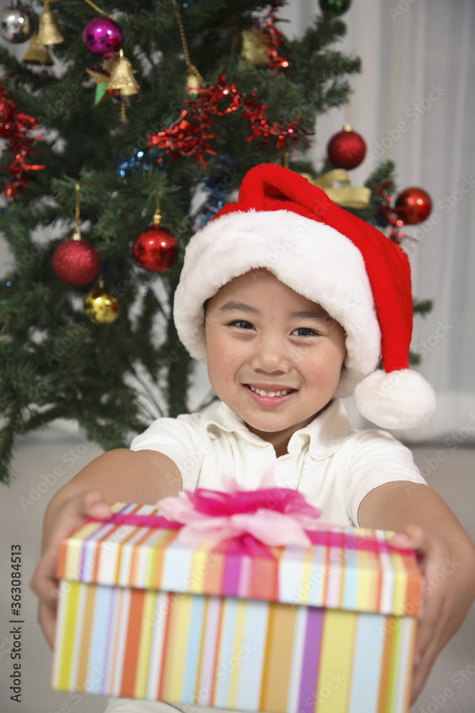 Boy with Christmas hat holding a box of gift Boy with Christmas hat holding a box of gift