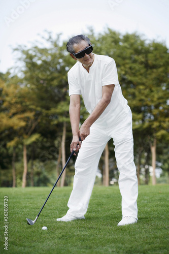 Senior man with sunglasses playing golf