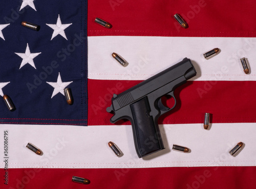 Top View of Black Handgun on American Flag with Bullets photo