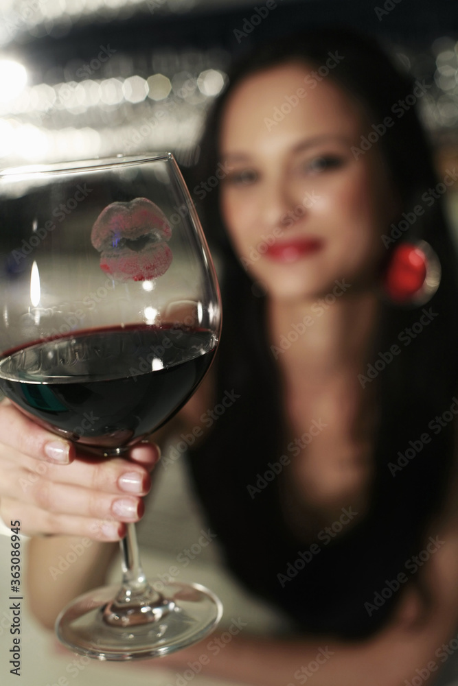 Woman showing glass with lipstick kiss on it Woman showing glass with lipstick kiss on it