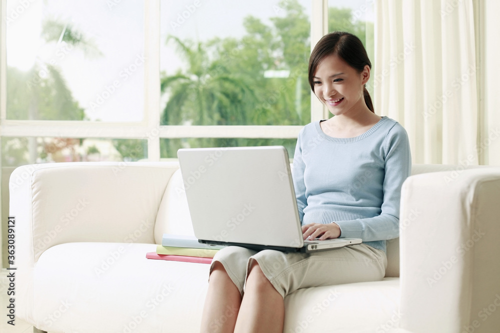 Woman sitting on the couch using laptop Woman sitting on the couch using laptop