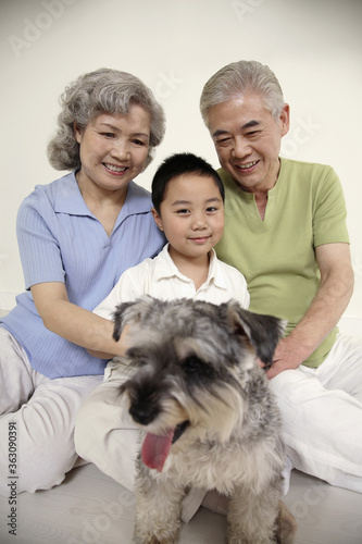 Senior couple and boy playing with dog