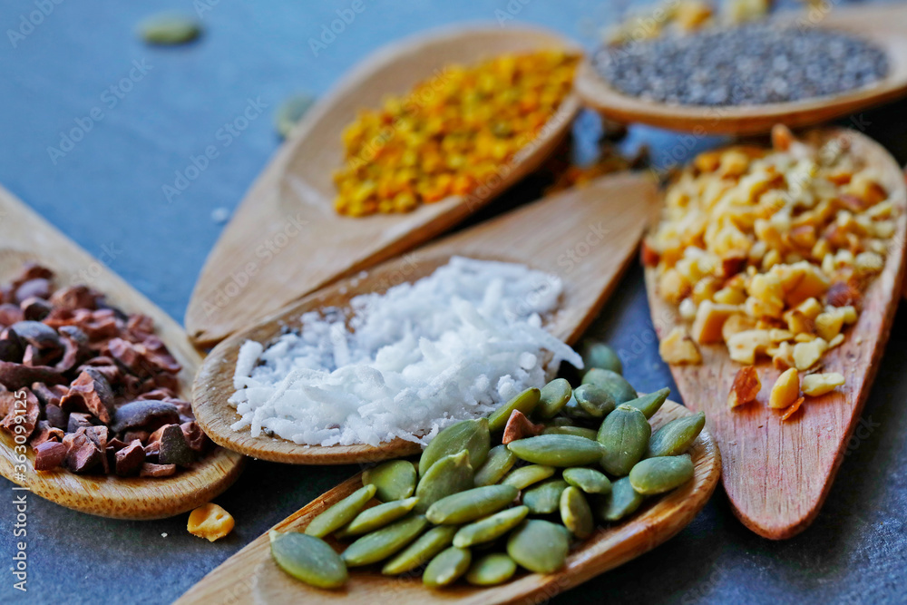 Various legumes and different kinds of nuts in spoons. Walnuts kernels ,hazelnuts, almond ,brown pinto ,soy beans ,flax seeds ,chia ,red kidney beans and pecan set up on white gray background Various legumes and different kinds of nuts in spoons. Walnuts kernels ,hazelnuts, almond ,brown pinto ,soy beans ,flax seeds ,chia ,red kidney beans and pecan set up on white gray background