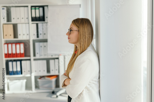 Fototapeta Naklejka Na Ścianę i Meble -  Young businesswoman standing deep in thought