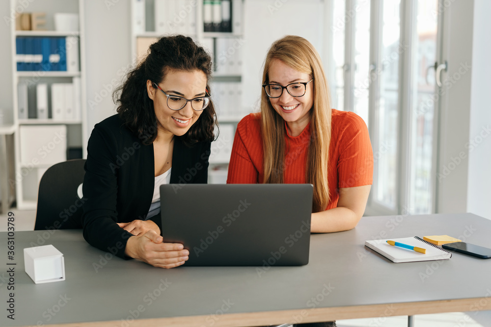 Two hardworking young woman working as a team Two hardworking young woman working as a team