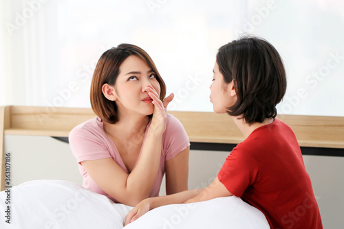 Happy Couple asia woman bored with bad breath in bedroom morning.