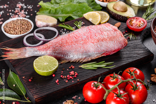 Raw fillet of red sea perch prepared for baking with spices and herbs
