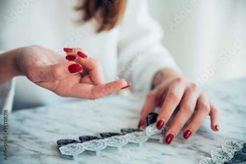 Obraz na płótnie Manos de mujer cogiendo lentes de contacto
