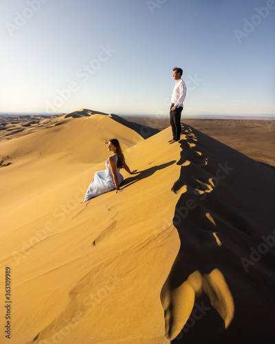 Young couple posing on the top of Khongorin sand dune in Gobi desert, Mongolia photo