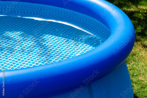 Part of a blue inflatable pool in the backyard of a private house.