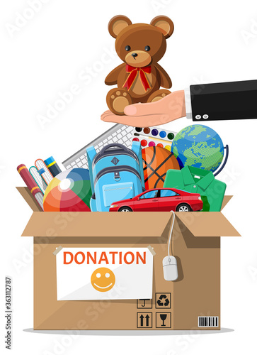 Cardboard donation box full of toys, books, clothes and devices. Help for children, support for poor kid. Donate container in hand. Social care, volunteering, charity concept. Flat vector illustration