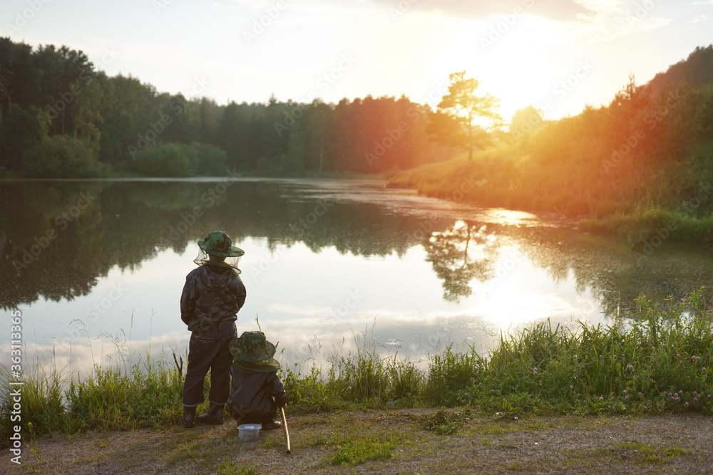 two boys fishing at sunset