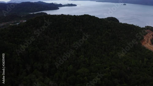 Coastal region of the Langkawi island and the beautiful dark green forest along with mountains ahead. Impressive landscapes and vast blue sea.