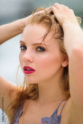 Intimate woman portrait with red hair and against blurred background.