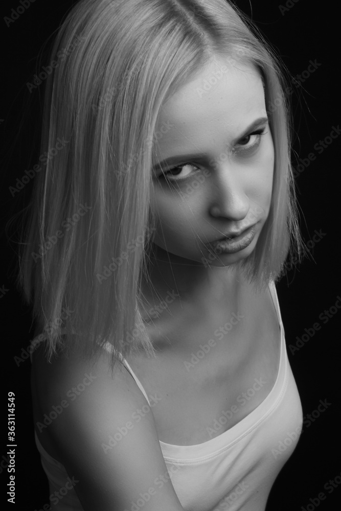 black-and-white portrait of a blonde on a black background.