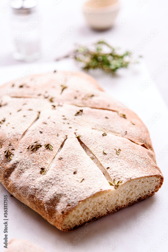 Homemade fresh baked Fougasse (French Bread) with thyme and olive oil on white background. Traditional Provencal dishes. Selective focus Homemade fresh baked Fougasse (French Bread) with thyme and olive oil on white background. Traditional Provencal dishes. Selective focus
