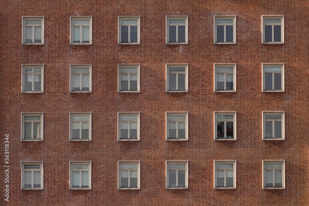 Many windows in a row on the wall of urban apartment building