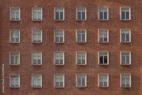 Many windows in a row on the wall of urban apartment building © lmanju