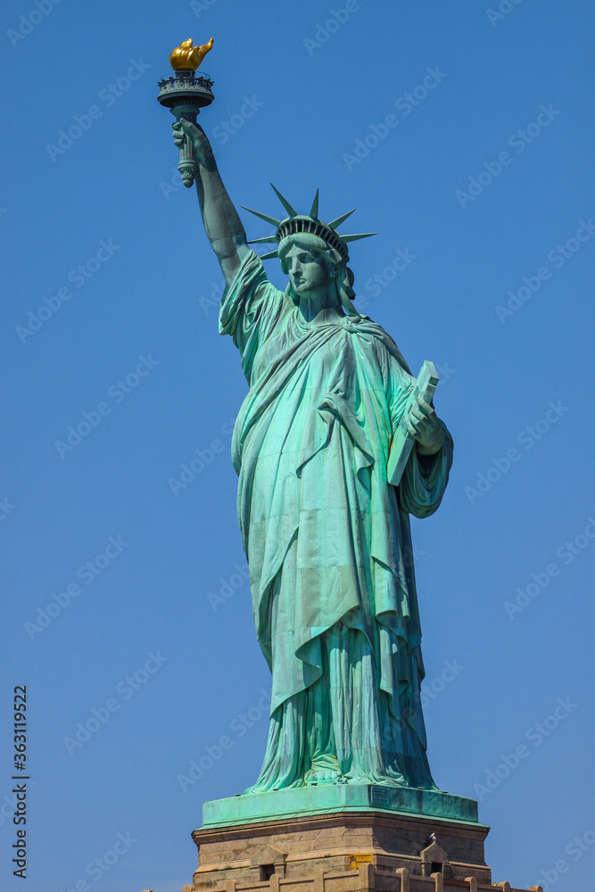 Obraz premium Close shot of Statue of Liberty in New York City, with blue sky.