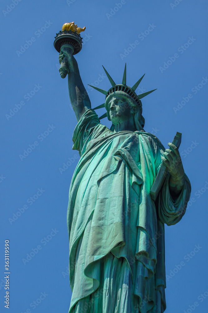 Fototapeta premium Close shot of Statue of Liberty in New York City, with blue sky.