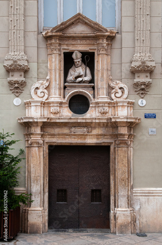 Casa del Punto de Gancho carved stone statue on building facade at plaza de la Almoina near Valencia Cathedral photo