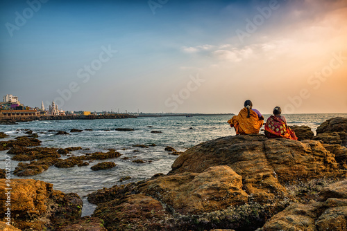 Two women enjoying sunrise in Kanyakumari, Tamil Nadu, India.