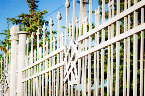 White iron fence. Metal iron, forged lattice in the park. Close-up.