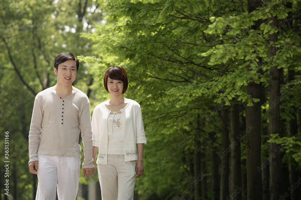Man and woman holding hands while walking in the park Man and woman holding hands while walking in the park