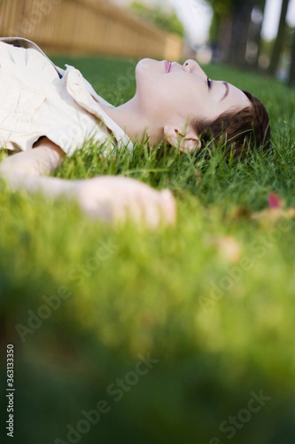 Woman lying on the grass with her eyes closed