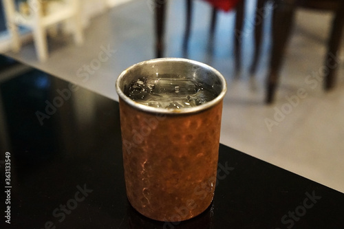 Close up bronze cup of iced spring water