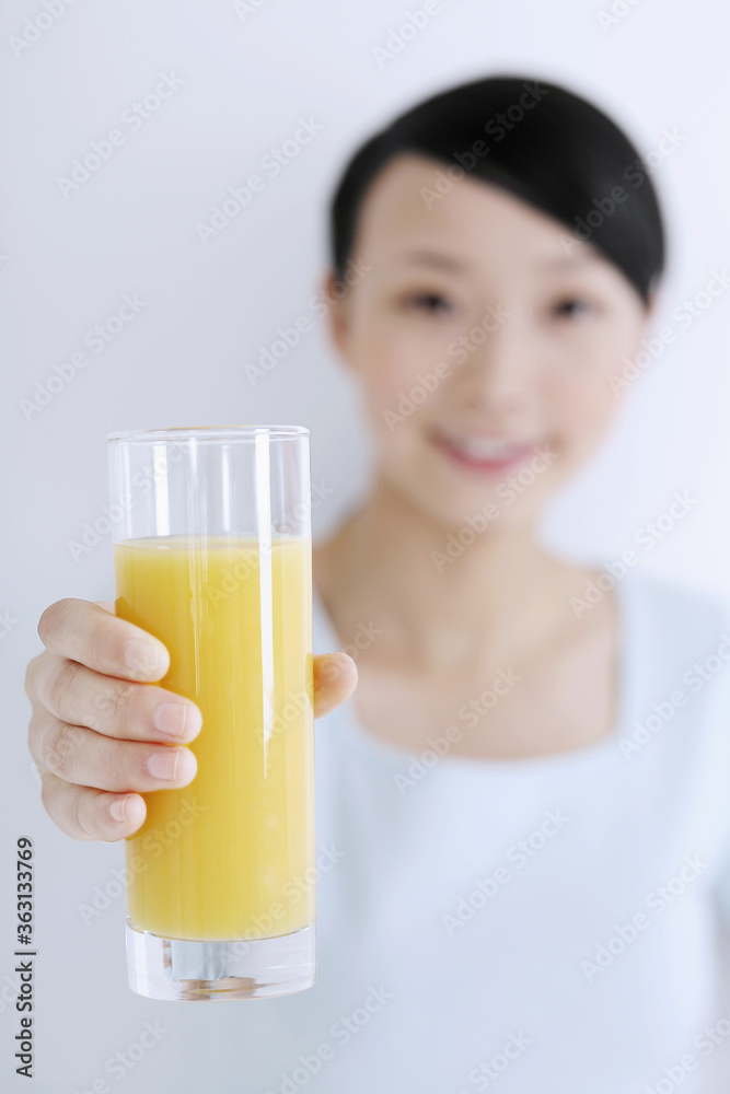Woman holding a glass of orange juice, smiling Woman holding a glass of orange juice, smiling