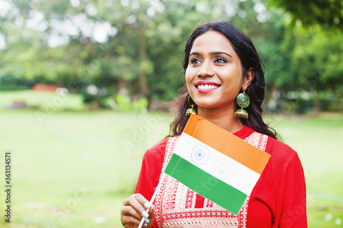 Indian woman in ethnic clothes holding Indian flag on national celebration (Independence day / Republic day) photo