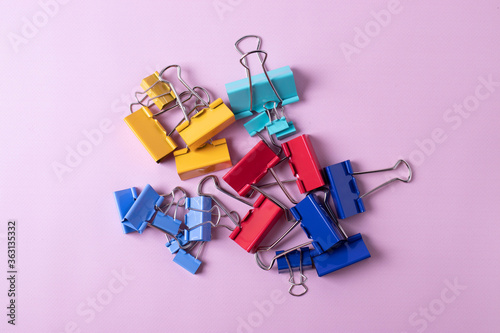 a group of colourful paper clips on pink background