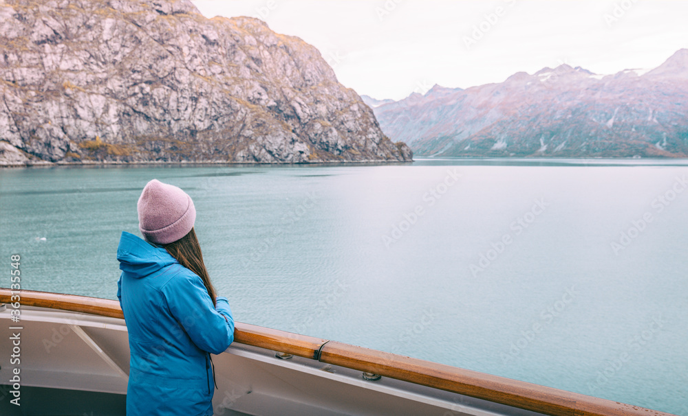 Alaska cruise Inside passage travel tourist woman looking at mountains landscape from balcony deck of ship. Glacier bay scenic vacation travel holiday.