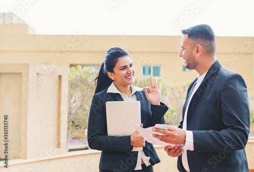 Canvastavla Business woman in suit showing ok sign to an indian man holding document