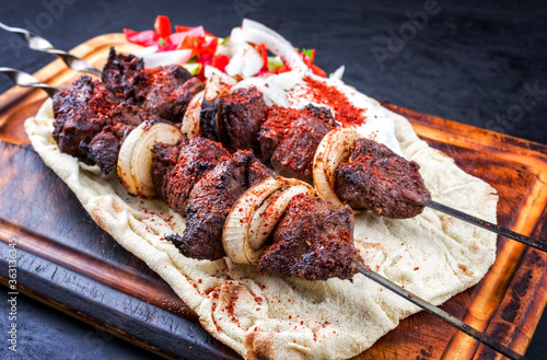 Traditionelle griechische Souvlaki Lamm Grillspieße mit Paprika, Pita Brot und Zaziki angeboten als Draufsicht auf einem rustikalen Holz Board