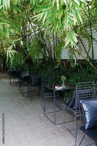 Exterior design and restaurant decoration of outdoor dining seats decorated with metal furniture in green bamboo garden park