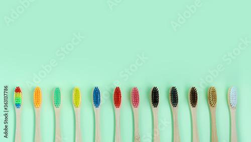 Set of multi-colored wooden toothbrushes on a green background. The concept of zero waste  medicine  recycling  eco friendly.Flat lay with copy space.