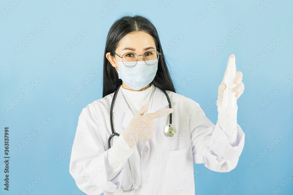 Smart young asian woman doctor in lab coat with Medical face mask,white latex medical gloves and stethoscope against blue background,health care concept Smart young asian woman doctor in lab coat with Medical face mask,white latex medical gloves and stethoscope against blue background,health care concept
